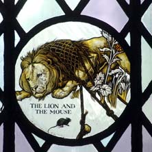 Stained glass picturing Aesop's The Lion and the Mouse