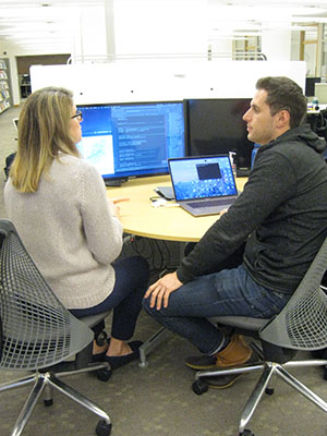 Woman and man sitting in front of computers