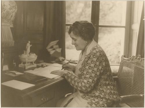 Black and white photo of Edith Wharton at her writing desk