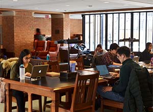 students studying at table with laptops