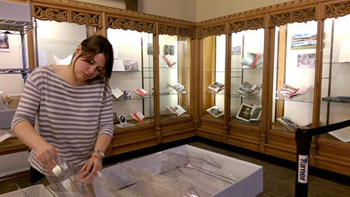 Elizabeth Morris installing 2016 "Moving Earth" exhibit in Memorabilia Room