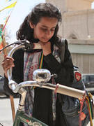 Young actress looks at a bicycle in the film Wadjda.