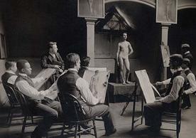 Black and white photo of male artists sketching female model 