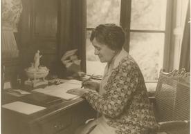 Black and white photo of Edith Wharton at her writing desk