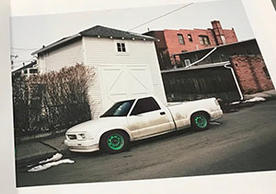 photo book page showing parked car in front of buildings