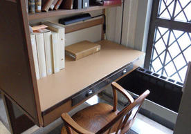 A carrel in the tower of Sterling Memorial Library, with a chair and small cubicle seating.