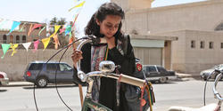 Young actress looks at a bicycle in the film Wadjda.